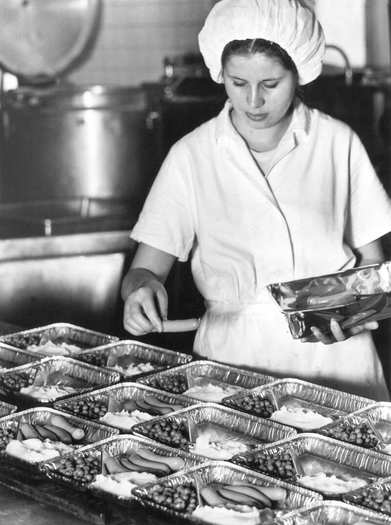 Kuvassa on nainen pakkaamassa valmisruokaa 1970-luvulla.