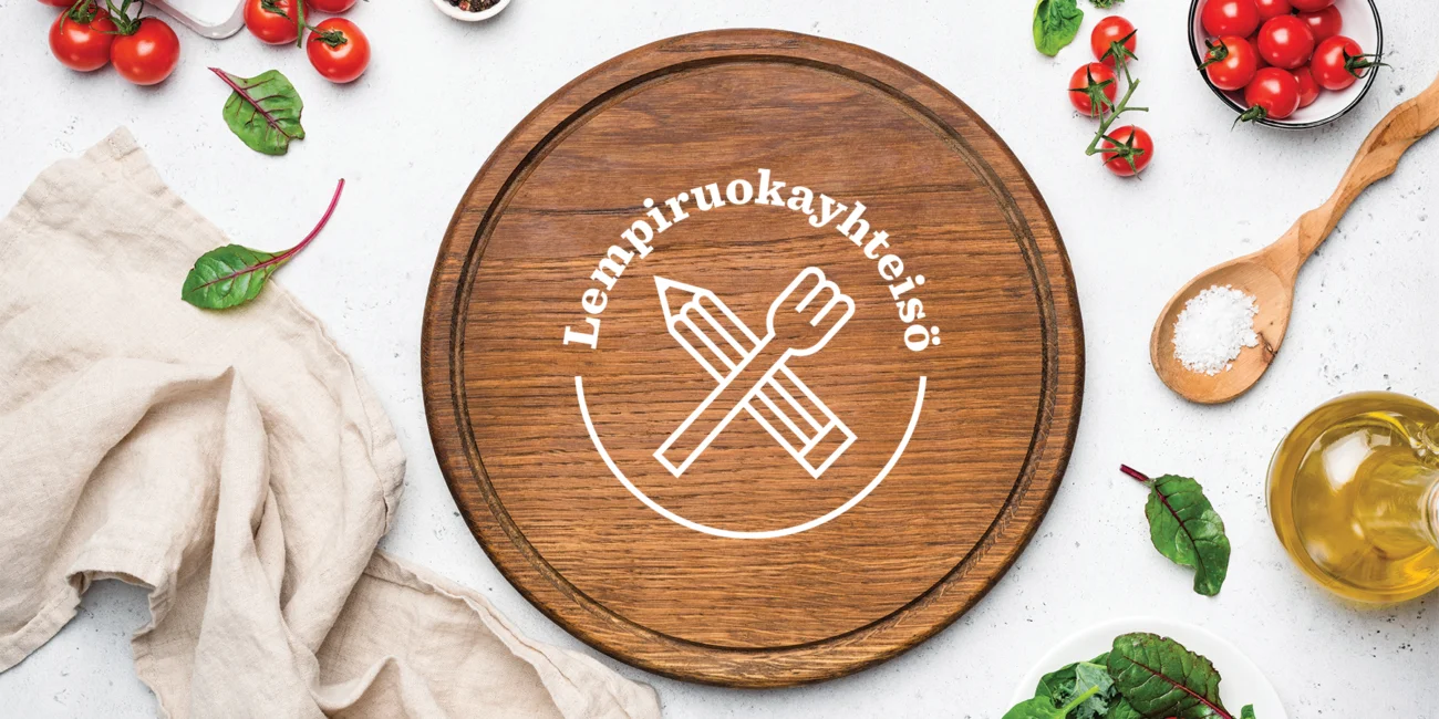 Kuvassa on puulautanen ja kasviksia. Lautasen keskellä teksti Lempiruokayhteisö.