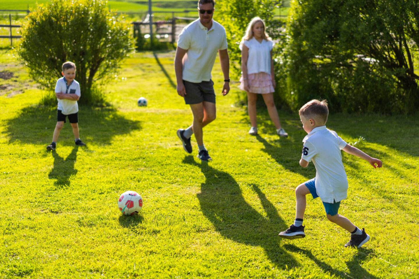 Kuvassa on perhe pelaamassa jalkapalloa.