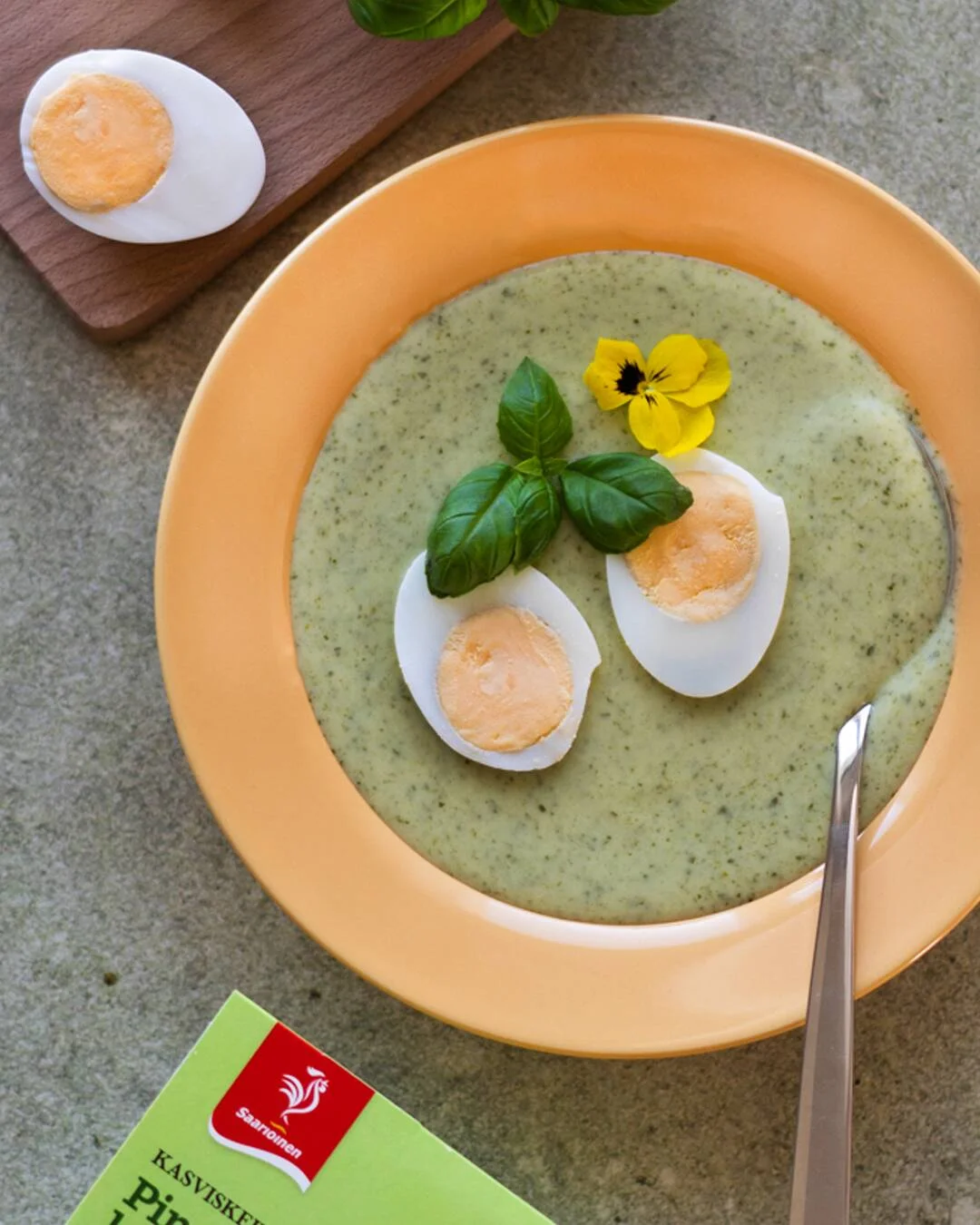 Kuvassa on lautasella Saarioisten Pinaattikeittoa, jonka päällä on kananmunanpuolikkaat.