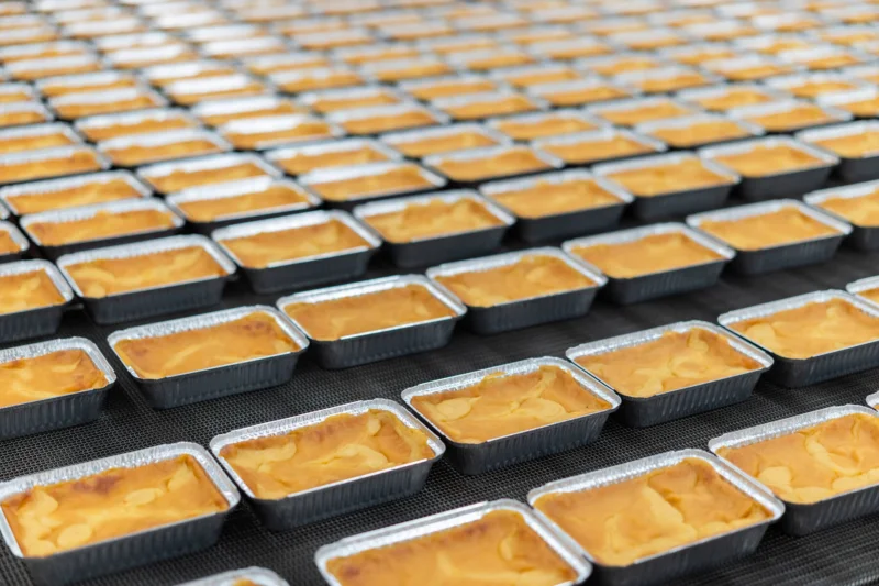 Kuvassa on Saarioisten laatikkoja tehtaalla rivissä.