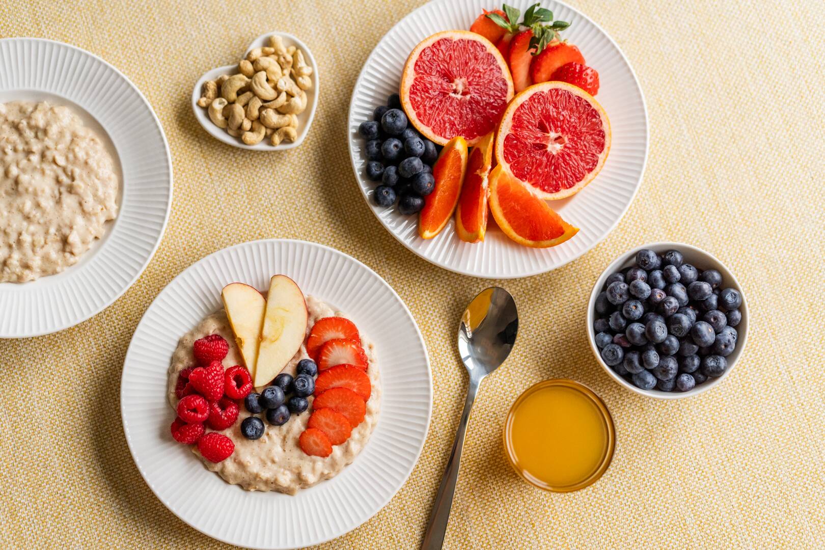 Kuvassa on kaksi puurolautasta ja runsaasti hedelmiä