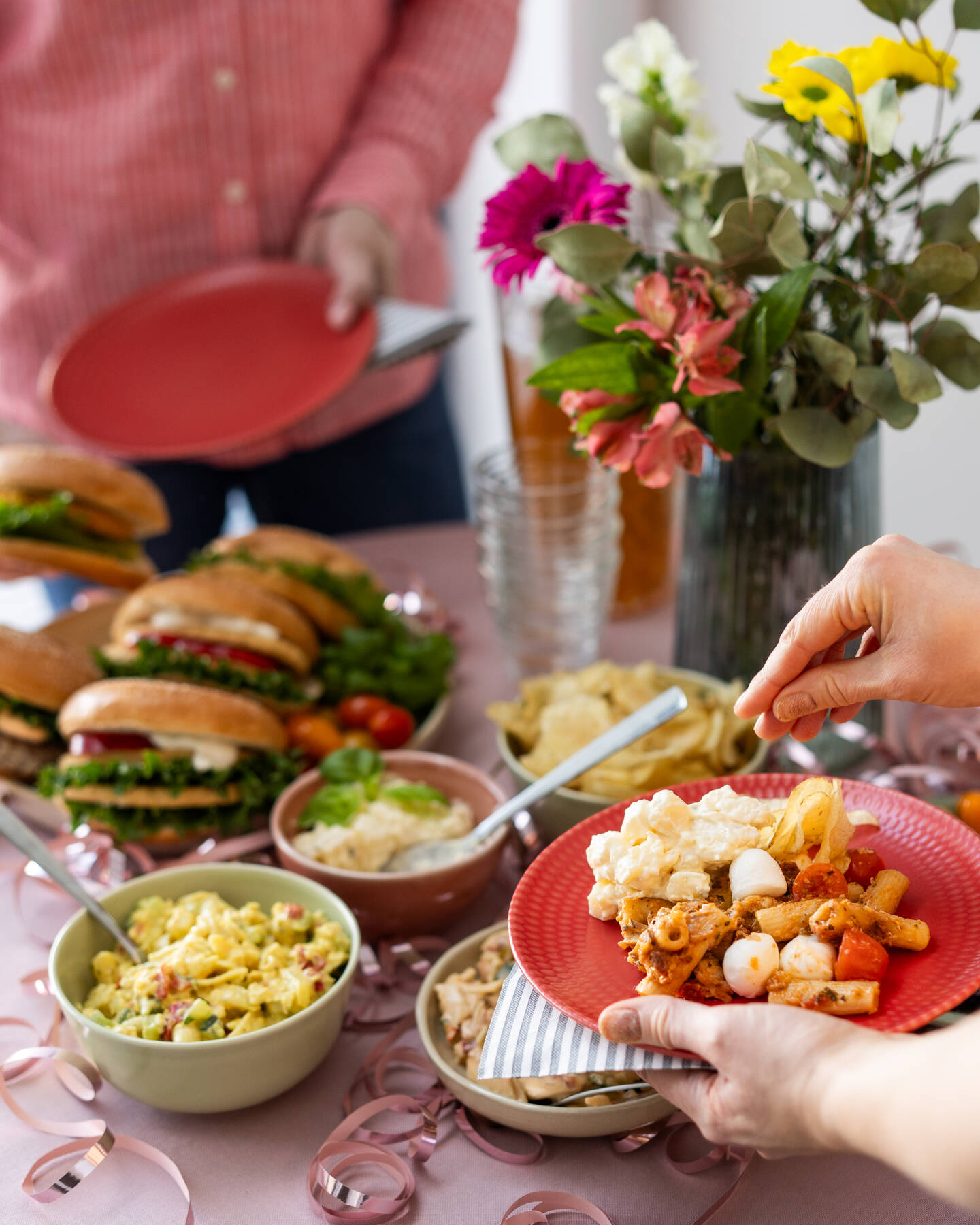 Kuvassa on vapun buffetpöytä ja erilaisia salaatteja ja burgereita sekä pikkunaposteltavaa