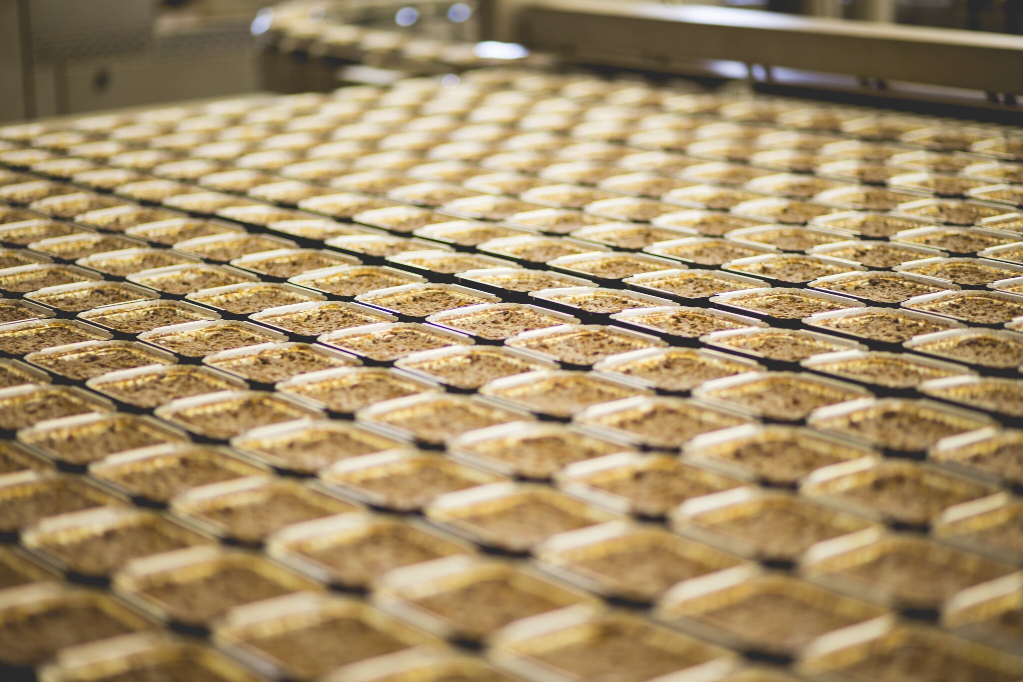 Alumiinivuokia tehtaan linjastolla tulossa uunista.